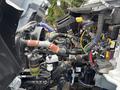 Close-up of the engine components of a 2025 Peterbilt 536 featuring various hoses, wires, and tanks in a complex assembly