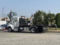 2020 Peterbilt 330 flatbed truck with a white cab and black flatbed trailer parked on a lot