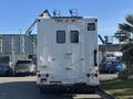 White 2008 International 4400 vehicle with a flat rear and several mounted lights and equipment on top