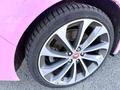 Close-up of a silver alloy wheel of a 2020 Jaguar XE featuring a Jaguar logo with a black tire tread pattern visible
