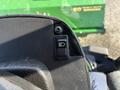 Close-up of a switch for headlights on a John Deere 1575 mower with a textured black surface and a simple light symbol