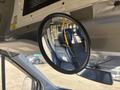 A round rearview mirror reflecting the interior of a 2017 Ford Transit-350 with seats visible in the background