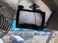A rearview camera display showing a parking surface with a vehicle's rear bumper in view