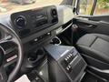 Interior view of a 2020 Mercedes-Benz Sprinter 2500 showing dashboard controls a gear shifter and a black console with buttons and cup holders