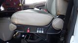 A driver's seat of a 2003 International 5600i with controls and switches visible on the side and worn upholstery on the left side