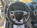 Steering wheel of a 2017 Ford Transit-350 featuring the Ford logo controls for cruise and audio settings and a gear shift lever on the side
