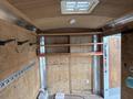 Interior of a 2016 Continental cargo trailer featuring wooden paneling shelves on both sides and hooks for storage