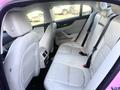 A 2020 Jaguar XE with a spacious rear seating area featuring white leather upholstery and seat belts