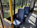 Interior of a 2018 Ford Transit-350 showcasing two blue upholstered seats equipped with seatbelts and a yellow grab handle