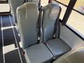 Two gray upholstered seats with seatbelts designed for a bus interior