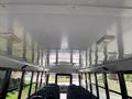 Interior view of a 2011 Freightliner B2 school bus with a smooth ceiling and rows of blue seats visible