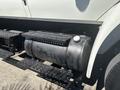 A large black fuel tank mounted on a truck chassis with metal supports and a circular cap on top