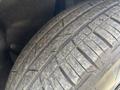 A close-up view of a worn tire showcasing tread patterns on a 2023 Fisker Ocean vehicle