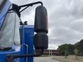 The image shows a side view mirror of a blue 2013 International DuraStar 4300 truck with a cylindrical shape and an integrated orange reflector