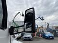 A 2025 Peterbilt 536 truck featuring a side mirror in focus with a clear reflection of its surroundings