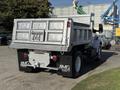A 2017 Ford F-650 Super Duty dump truck with a large silver dump bed and black rear fenders showcasing the company logo on each side