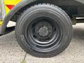A close-up view of a black Michelin tire mounted on a wheel of a 2010 Ford F-550 Super Duty truck