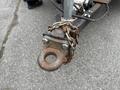 A close-up view of a rusted hitch attached to a 2016 Continental cargo trailer secured with a heavy chain and bolts