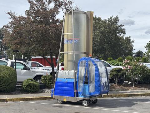 A 2023 Bitimec SC415 is a compact, electric vehicle with a blue protective cover and a large cylindrical metal component on top designed for cleaning tasks