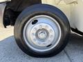 Close-up of a silver wheel on a 2011 International 4300 featuring a black tire with visible tread and multiple lug nuts securing the wheel to the hub