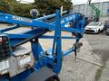 A blue 2016 Genie TZ-34/20 aerial lift with a raised boom arm, control panel on the side and a platform attached at the end