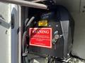 A control panel with a warning label attached to a box containing hydraulic lines and a key switch on a 2006 International 4300 vehicle