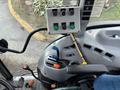 Interior view of a 2009 New Holland T4020 tractor showing the control panel with various colored buttons and levers in the driver's seat area