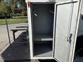 A 2005 Freightliner M2 106 truck with an open compartment revealing a spacious interior empty of contents