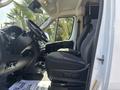 The interior of a 2022 RAM Promaster 350 showing the driver's seat dashboard and steering wheel with fabric upholstery and various controls