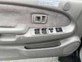 Interior door panel of a 2004 Toyota Tacoma featuring window controls and a speaker