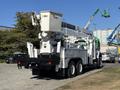 A 2013 International 7500 bucket truck with a raised aerial platform and equipment for utility work in the cargo area