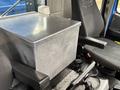 A metallic storage box sits between two seats in a 2017 Autocar Xpert vehicle