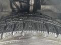 Close-up of a tire from a 2021 Ford Transit-350 showing a rugged tread pattern and visible moisture on the rubber surface