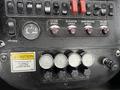 Dashboard controls of a 2013 International DuraStar 4300 featuring buttons and gauges for various functions including speed and broom control