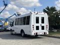 A white 2018 Ford Transit-350 with large windows and a dual rear door parked in a lot