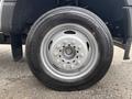 A close-up of a silver wheel and tire of a 2023 Ford F-450 Super Duty showing the tire tread and bolt pattern