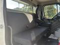 Interior view of a 2022 Freightliner M2 106 showing two gray seats with fabric upholstery and seatbelts in the driver's compartment