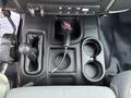 Black center console of a 2013 RAM 5500 showing gear shift lever cup holders and auxiliary input port