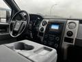 Interior view of a 2014 Ford F-150 featuring a steering wheel dashboard and center console with controls and a display screen