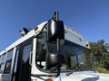 A 2013 International CE300 school bus with large side mirrors and a white exterior