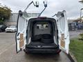 A 2019 Ford Transit Connect van with its doors open revealing a cargo area that contains two black tires