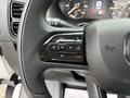 Close-up of the steering wheel controls of a 2023 RAM Promaster 3500 featuring buttons for phone, menu navigation, and cruise control settings