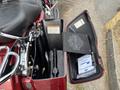 A 2009 Harley-Davidson Road King with an open saddlebag revealing contents including a tool and a pack of wipes