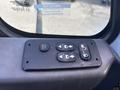 A control panel featuring four buttons for window controls and door locking on the interior of a 2008 International 4400 truck