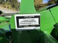 A green John Deere 1575 lawn mower with a label displaying the model information and serial number
