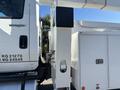 A 2013 International 7500 truck with a white body and side compartment designed for utility work