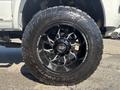 Close-up of a black wheel and tire from a 2018 RAM 3500 showing intricate spoke design and aggressive tread pattern