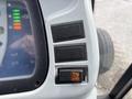 Close-up of the control panel of a 2009 New Holland T4020 featuring buttons and indicator lights for various functions