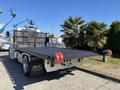 A 2020 Peterbilt 330 tow truck featuring a flatbed with red rubber bumpers and a black textured surface designed for transporting vehicles