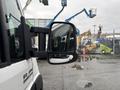 A 2023 RAM Promaster 3500 with a side mirror reflecting the surroundings and rain droplets on its surface